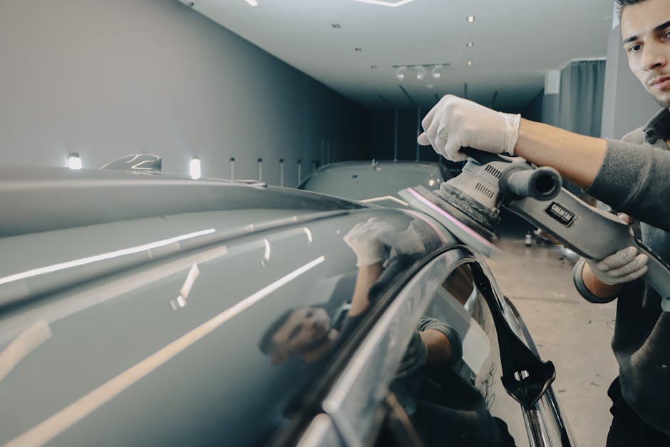 Professional auto detailer meticulously working on a vehicle